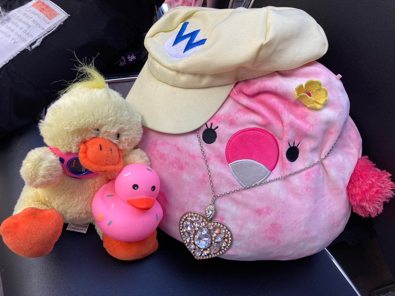 Pink Squishmallow, wario hat on, love heart necklace. Pink donut ducky. Ducky plush.