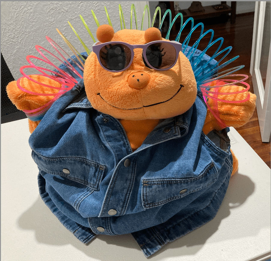 Butterfly plushy,purple sunnies,denim outfit, holding slinky above head with hands